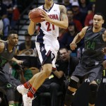 Arizona's Brandon Ashley (21) passes between Oregon's Jalil Abdul-Bassit, left, and Oregon's Dillon Brooks during the first half of an NCAA college basketball game in the championship of the Pac-12 conference tournament Saturday, March 14, 2015, in Las Vegas. (AP Photo/John Locher)