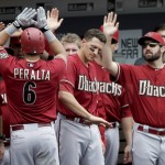Arizona Diamondbacks' David Peralta (6) is greeted by teammates in the dugout after hitting a home run against the San Diego Padres during the third inning of a baseball game Sunday, June 28, 2015, in San Diego. (AP Photo/Gregory Bull)
