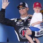Kevin Harvick and his son Keelan wave to the fans before a NASCAR Sprint Cup Series auto race on Sunday, March 15, 2015, in Avondale, Ariz. (AP Photo/Rick Scuteri)