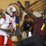 Utah's Travis Wilson, left, tries to elude the pass rush of Arizona State's Marcus Hardison (1) in the first half of an NCAA college football game on Saturday, Nov. 1, 2014, in Tempe, Ariz. (Photo/Ross D. Franklin)