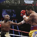 Floyd Mayweather Jr., left, punches Manny Pacquiao, from the Philippines, during their welterweight title fight on Saturday, May 2, 2015 in Las Vegas. (AP Photo/Isaac Brekken)