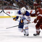  Edmonton Oilers' Sam Gagner (89) skates in front of Phoenix Coyotes' Derek Morris (53) during the first period of an NHL hockey game, Friday, April 4, 2014, in Glendale, Ariz. (AP Photo/Ross D. Franklin)