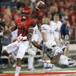 Nevada defensive back Tere Calloway (30) commits pass interference on Arizona running back Samajie Grant (10) during the first half of the NCAA college football game, Saturday, Sept. 13, 2014, in Tucson, Ariz. (AP Photo/Rick Scuteri)