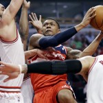 Washington Wizards guard Bradley Beal (3), center, drives to the basket against Chicago Bulls center Joakim Noah, left, and forward Carlos Boozer (5) during the first half in Game 1 of an opening-round NBA basketball playoff series in Chicago, Sunday, April 20, 2014. (AP Photo/Nam Y. Huh)