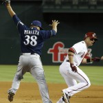 Arizona Diamondbacks' Martin Prado, right, is out at first base as Milwaukee Brewers' Wily Peralta (38) reaches for the ball thrown to him for a double play during the eighth inning of a baseball game on Monday, June 16, 2014, in Phoenix. (AP Photo/Ross D. Franklin)