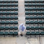  A stadium employee waits for the crowd to arrive while it rains before a baseball game between the Chicago Cubs and the Arizona Diamondbacks on Monday, April 21, 2014, in Chicago. (AP Photo/Andrew A. Nelles)