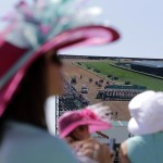 Fans watch a race before the 141th running of the Kentucky Oaks horse race at Churchill Downs Friday, May 1, 2015, in Louisville, Ky. (AP Photo/Jeff Roberson)
