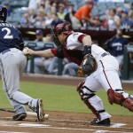 Arizona Diamondbacks' Miguel Montero, right, tags Milwaukee Brewers' Scooter Gennett (2) out after the third strike was dropped by Montero during the first inning of a baseball game on Monday, June 16, 2014, in Phoenix. (AP Photo/Ross D. Franklin)