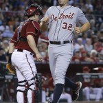 Detroit Tigers' Don Kelly (32) scores on a two-RBI double by teammate Alex Avila as Arizona Diamondbacks catcher Miguel Montero waits for the throw during the second inning of a baseball game, Wednesday, July 23, 2014, in Phoenix. (AP Photo/Matt York)