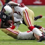 Arizona Cardinals wide receiver Ted Ginn Jr. (19) is hit by San Francisco 49ers cornerback Chris Cook (22) during the first half of an NFL football game, Sunday, Sept. 21, 2014, in Glendale, Ariz. (AP Photo/Rick Scuteri)