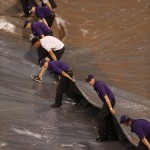 Field guards pull the tarpaulin after a heavy rainstorm packing hail swept over the metropolitan area before the first inning of a baseball game between the Arizona Diamondbacks and Colorado Rockies Wednesday, June 24, 2015, in Denver. (AP Photo/David Zalubowski)