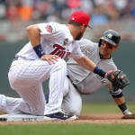 New York Yankees' Brian Roberts, right, beats the tag by Minnesota Twins' Trevor Plouffe to triple in the fourth inning of a baseball game on Friday, July 4, 2014, in Minneapolis. (AP Photo/Jim Mone)