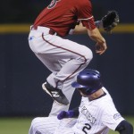 Arizona Diamondbacks shortstop Nick Ahmed, top, jumps over Colorado Rockies' Troy Tulowitzki after forcing him out at second base on the front end of a double play hit into by Ben Paulsen to end the first inning of a baseball game Wednesday, June 24, 2015, in Denver. (AP Photo/David Zalubowski)
