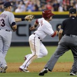 Arizona Diamondbacks' Gerardo Parra eludes the tag of Cleveland Indians' Asdrubal Caabrera (13) as umpire Vic Carapazza watches during the sixth inning of a baseball game, Tuesday, June 24, 2014, in Phoenix. Parra was ruled safe after avoiding the tag in a rundown. (AP Photo/Matt York)

