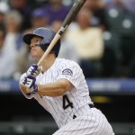 Colorado Rockies catcher Nick Hundley follows the flight of his two-run home run against the Arizona Diamondbacks in the seventh inning of the first game of a baseball doubleheader, Wednesday, May 6, 2015, in Denver. (AP Photo/David Zalubowski)