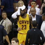 Cleveland Cavaliers forward LeBron James (23) holds a towel to his head after being knocked into the fans during the first half of Game 4 of basketball's NBA Finals against the Golden State Warriors in Cleveland, Thursday, June 11, 2015. (AP Photo/Paul Sancya)