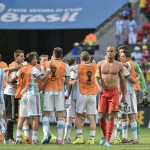 Belgium's Vincent Kompany walks away as Argentina players celebrate after the World Cup quarterfinal soccer match between Argentina and Belgium at the Estadio Nacional in Brasilia, Brazil, Saturday, July 5, 2014. Argentina won the match 1-0. (AP Photo/Martin Meissner)