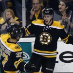 Boston Bruins right wing Reilly Smith, right, celebrates his goal with center Patrice Bergeron (37) in the first period of an NHL hockey game against the Philadelphia Flyers in Boston, Wednesday, Oct. 8, 2014. (AP Photo/Elise Amendola)