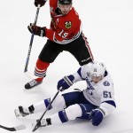 Tampa Bay Lightning's Valtteri Filppula, of Finland, falls as he chases after a loose puck with Chicago Blackhawks' Jonathan Toews, top, during the first period in Game 6 of the NHL hockey Stanley Cup Final series on Monday, June 15, 2015, in Chicago. (AP Photo/Charles Rex Arbogast)