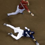 Milwaukee Brewers' Carlos Gomez is out at second as Arizona Diamondbacks shortstop Cliff Pennington turns a double play on a ball hit by Milwaukee Brewers' Scooter Gennett during the sixth inning of a baseball game Wednesday, May 7, 2014, in Milwaukee. (AP Photo/Morry Gash)
