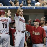 Arizona Diamondbacks' David Peralta, center, points to teammate Miguel Montero on first base after Montero hit an RBI-single, driving home Mark Trumbo (15) while playing the San Diego Padres during the third inning of a baseball game Thursday, Sept. 4, 2014, in San Diego. (AP Photo/Gregory Bull)