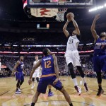 New Orleans Pelicans forward Anthony Davis (23) goes to the basket between Phoenix Suns forward Markieff Morris (11) and forward T.J. Warren (12) in the first half of an NBA basketball game in New Orleans, Friday, April 10, 2015. The Pelicans won 90-75. (AP Photo/Gerald Herbert)

