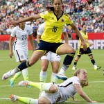 United States' Becky Sauerbrunn (4) falls as Colombia's Yoreli Rincon (10) jumps over during second half FIFA Women's World Cup round of 16 soccer action in Edmonton, Alberta, Canada, Monday, June 22, 2015. (Jason Franson/The Canadian Press via AP) 