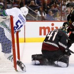 Arizona Coyotes' Mike Smith (41) makes a save on a shot by Vancouver Canucks' Derek Dorsett (51), who ends up in the net, as Coyotes' Connor Murphy (5) defends during the first period of an NHL hockey game Thursday, March 5, 2015, in Glendale, Ariz. (AP Photo/Ross D. Franklin)