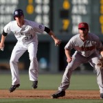  Colorado Rockies base runner Justin Morneau, left, jumps in the air as he takes a lead off first base as Arizona Diamondbacks first baseman Nick Evans covers in the first inning of a baseball game in Denver on Tuesday, June 3, 2014. (AP Photo/David Zalubowski)