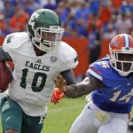 Eastern Michigan quarterback Reginald Bell Jr. (10) scrambles as he tries to get past Florida defensive lineman Alex McCalister (14) during the first half of an NCAA college football game in Gainesville, Fla., Saturday, Sept. 6, 2014. (AP Photo/John Raoux)