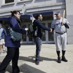 Kevin Tracy, dressed as the New York Yankees' Babe Ruth, right, shakes hands with a Yankees' fan before an opening day baseball game against the Toronto Blue Jays at Yankee Stadium, Monday, April 6, 2015 in New York. (AP Photo/Seth Wenig)