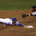 Kansas City Royals' Omar Infante slides safely past San Francisco Giants catcher Buster Posey during the fifth inning of Game 6 of baseball's World Series Tuesday, Oct. 28, 2014, in Kansas City, Mo. Infante scored from first on a double by Alcides Escobar. (AP Photo/Jeff Roberson)
