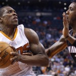 Phoenix Suns' Eric Bledsoe, left, tries to go up for a shot against Miami Heat's Mario Chalmers (15) during the second half of an NBA basketball game Tuesday, Dec. 9, 2014, in Phoenix. The Heat won 103-97. (AP Photo/Ross D. Franklin)