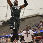 Michigan State's Branden Dawson (22) dunks the ball in front of Louisville's Mangok Mathiang (12), of Australia, during the second half of a regional final in the NCAA men's college basketball tournament Sunday, March 29, 2015, in Syracuse, N.Y. (AP Photo/Seth Wenig)