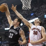 Brooklyn Nets' Mizra Teletovic, left, gathers a defensive rebound in front of Toronto Raptors' Tyler Hansbrough during the first half of Game 1 of an opening-round NBA basketball playoff series, in Toronto on Saturday, April 19, 2014. (AP Photo/The Canadian Press, Chris Young)