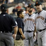 San Francisco Giants first baseman Brandon Belt, center, is checked on by the trainer as manager Bruce Bochy, right, looks to his bench during the fourth inning of a MLB baseball game, Tuesday, April 7, 2015, in Phoenix. Belt left the game with an injury. Watching, back to camera, is umpire Rob Drake. (AP Photo/Matt York)