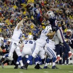 New England Patriots defensive end Chandler Jones (95) leaps over Indianapolis Colts guard Lance Louis (60) as quarterback Andrew Luck passes during the first half of the NFL football AFC Championship game Sunday, Jan. 18, 2015, in Foxborough, Mass. (AP Photo/Matt Slocum)