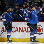 Colorado Avalanche left wing Cody McLeod, front right, is congratulated for scoring a goal as he passes by the team box with defenseman Zach Redmond against the Arizona Coyotes in the first period of an NHL hockey game Monday, Feb. 16, 2015, in Denver. (AP Photo/David Zalubowski)