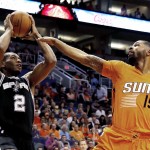 San Antonio Spurs forward Kawhi Leonard (2) shoots against Phoenix Suns forward Marcus Morris (15) in the first quarter of an NBA basketball game, Friday, Oct. 31, 2014, in Phoenix. (AP Photo/Rick Scuteri)