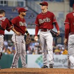 Arizona Diamondbacks starting pitcher Chase Anderson, center, waits for manager Kirk Gibson (23) to pull him during the fourth inning of a baseball game against the Pittsburgh Pirates in Pittsburgh Wednesday, July 2, 2014. (AP Photo/Gene J. Puskar)
