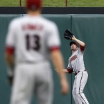 Arizona Diamondbacks shortstop Nick Ahmed (13) watches as center fielder A.J. Pollock reaches up to grab a fly out by Texas Rangers' Adrian Beltre during the first inning of a baseball game Tuesday, July 7, 2015, in Arlington, Texas. (AP Photo/Tony Gutierrez)
