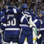 Tampa Bay Lightning players, from left, Nikita Kucherov (86), of Russia, Ben Bishop (30), Victor Hedman (77), of Sweden, and Tyler Johnson celebrate their 2-0 win over the Detroit Red Wings in Game 7 of a first-round NHL Stanley Cup hockey playoff series Wednesday, April 29, 2015, in Tampa, Fla. (AP Photo/Chris O'Meara)