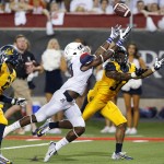 Arizona running back Davonte' Neal (19) and California cornerback Cedric Dozier (37) reach for a pass during the first half of an NCAA college football game, Saturday, Sept. 20, 2014, in Tucson, Ariz. (AP Photo/Rick Scuteri)