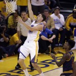 Golden State Warriors guard Klay Thompson scores over Cleveland Cavaliers guard Iman Shumpert during the first half of Game 5 of basketball's NBA Finals in Oakland, Calif., Sunday, June 14, 2015. (AP Photo/Eric Risberg)
