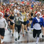 Participants dressed as Thomas Jefferson, from left, Benjamin Franklin, and George Washington lead the way down Peachtree Street at the start of the AJC Peachtree Road Race on Saturday, July 4, 2015, in Atlanta. The patriotic trio soon fell off the lead. (Curtis Compton/Atlanta Journal-Constitution via AP)

