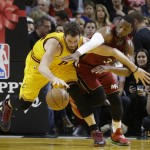 Cleveland Cavaliers forward Kevin Love (0) is defended by Miami Heat guard Dwyane Wade (3) during the first half of an NBA basketball game, Thursday, Dec. 25, 2014, in Miami. (AP Photo/Lynne Sladky)