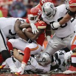 Kansas City Chiefs running back Jamaal Charles (25) is tackled by Oakland Raiders middle linebacker Miles Burris (56) and Oakland Raiders defensive end C.J. Wilson, right, during the first half of an NFL football game in Kansas City, Mo., Sunday, Dec. 14, 2014. (AP Photo/Orlin Wagner)