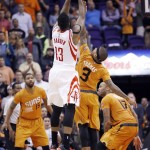 Houston Rockets' James Harden (13) shoots the game-winning shot as time expires in an NBA basketball game, as Phoenix Suns' Isaiah Thomas (3) defends and Suns' Marcus Morris (15) and P.J. Tucker (17) watch, Friday, Jan. 23, 2015, in Phoenix. The Rockets defeated the Suns 113-111. (AP Photo/Ross D. Franklin)