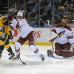 Buffalo Sabres right winger Brian Gionta (12) tangles with Arizona Coyotes defenseman John Moore, middle, as Coyotes goaltender Mike Smith, right, makes a save during the first period of an NHL hockey game Thursday, March 26, 2015, in Buffalo, N.Y. (AP Photo/Gary Wiepert)