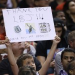 A boy holds up a sign thanking Cleveland Cavaliers' LeBron James for his time played with the Miami Heat during the second half of an NBA basketball game between the Heat and the Cavaliers, Thursday, Dec. 25, 2014, in Miami. The Heat defeated the Cavaliers 101-91. (AP Photo/Lynne Sladky)